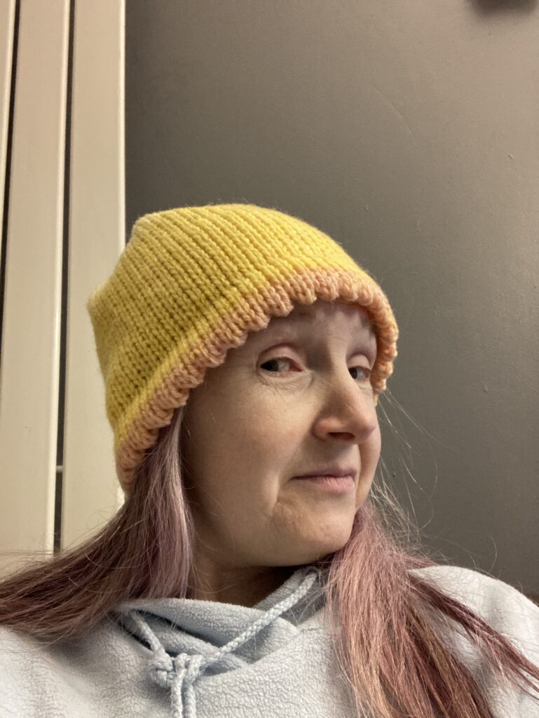 Gloria wearing the yellow sunflower version of bluebell inspired hat pattern